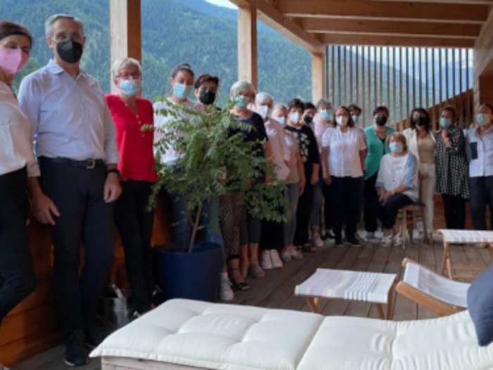 Frauen am Ruder Gruppe von Menschen mit Masken auf einer überdachten Terrasse in den Bergen