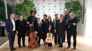 News Gruppe von zehn Menschen, zwei mit Musikinstrumenten, vor einem LVH-Hintergrund