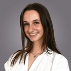 3-095-2603 Lächelnde junge Frau mit braunen Haaren vor grauem Hintergrund