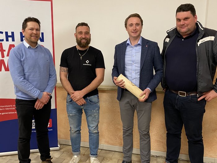 Zukunftsorientierte Weichenstellung: Ortsversammlung des Handwerks in Kiens Vier Männer stehen vor einem Plakat mit der Aufschrift Ich bin Handwerk