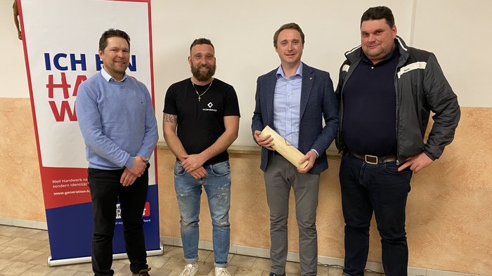 Zukunftsorientierte Weichenstellung: Ortsversammlung des Handwerks in Kiens Vier Männer stehen vor einem Plakat mit der Aufschrift Ich bin Handwerk