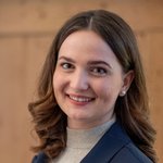 Klausen Porträt einer lächelnden jungen Frau mit braunen Haaren und Ohrsteckern