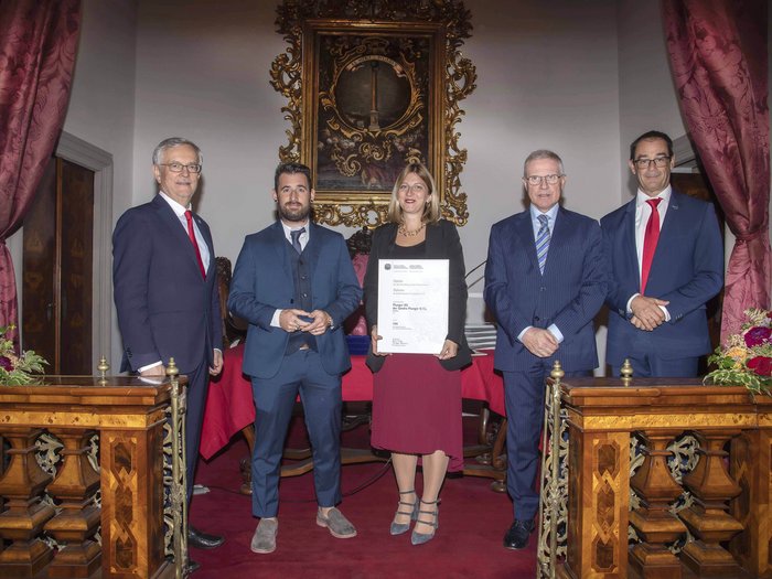 Premio Economia Alto Adige 2023: 6 aziende artigiane di lvh.apa insignite Cinque persone in abiti formali posano durante una cerimonia di consegna di un certificato in una sala elegante