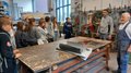 SkillsDay Schülergruppe hört in Werkstatt zwei Handwerkern zu