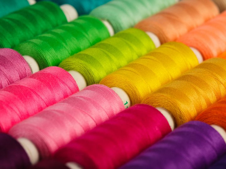 Magliai, ricamatori e tessitori File di bobine di filo colorate in vari colori