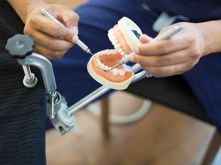 Odontotecnici Dentista pratica su modello di denti con strumenti
