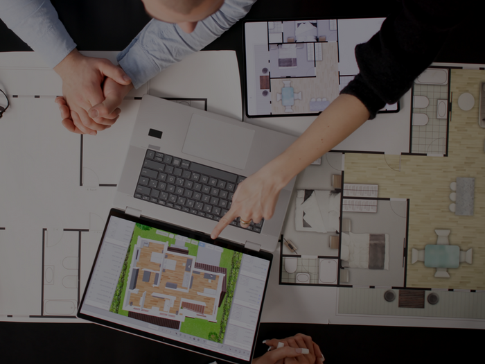 Mehr Platz für die Zukunft des Handwerks Personen besprechen Grundrisse und einen digitalen Wohnungsplan am Laptop