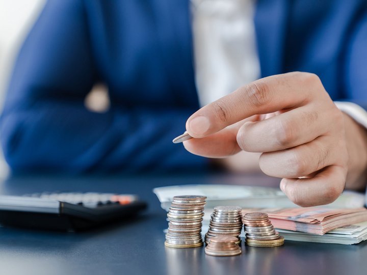 Consulenza bancaria e finanziamenti Persona conta monete e organizza banconote su un tavolo