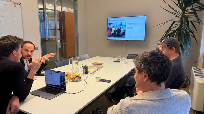 Innovationsförderung: Anwendungsrichtlinien angepasst Vier Personen bei einer Besprechung in einem Konferenzraum mit Laptop und Bildschirm