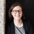 Das Nachhaltigkeitslabel Südtirol Lächelnde Frau mit Brille vor dunklem Hintergrund