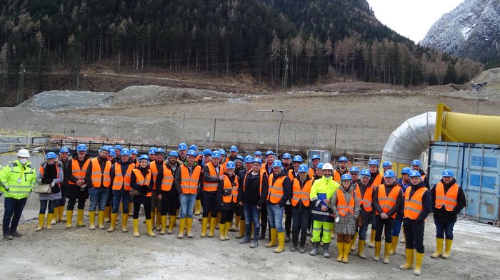 Tiefbauunternehmer: Preisanstiege als größte Herausforderung Große Gruppe von Bauarbeitern mit Helmen und Warnwesten auf Baustelle vor Bergland