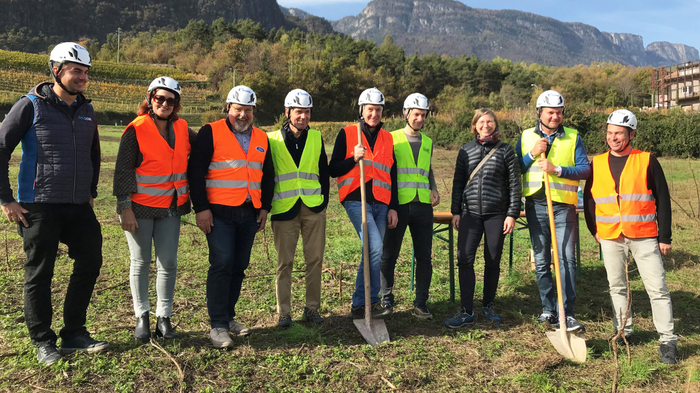 Eletto il nuovo presidente dei giovani imprenditori di Confartigianato: i giovani artigiani di lvh.apa erano presenti a Roma! Gruppo di nove persone con caschi e giubbotti riflettenti in un campo davanti alle montagne