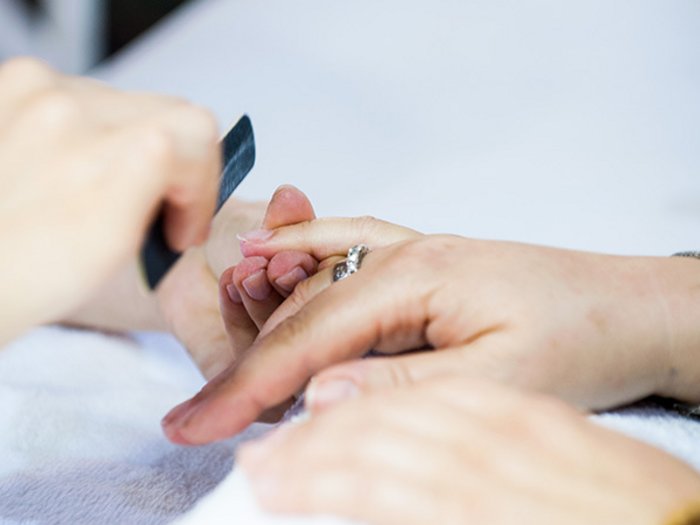 Grünes Licht für die Schönheitspflegesalons Fingernagelpflege bei einer Maniküre im Kosmetikstudio