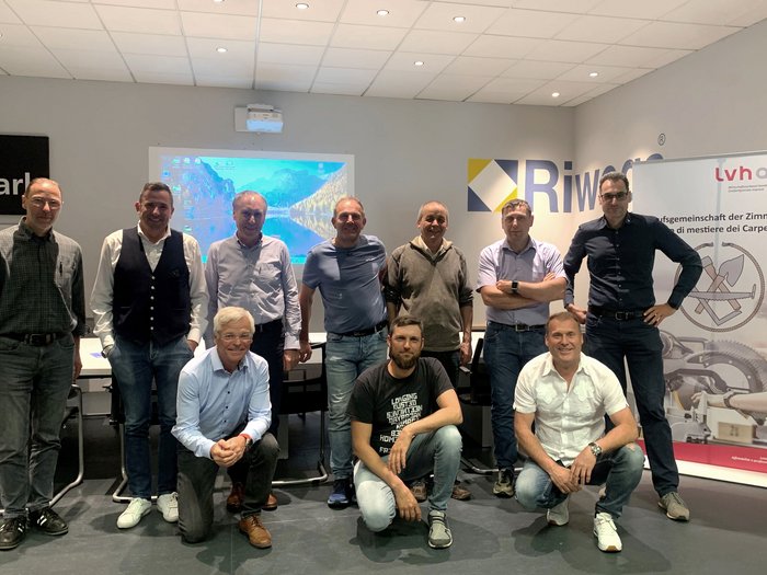 Presentazioni interessanti e tanta competenza all’assemblea annuale dei Costruttori in legno e carpentieri di lvh.apa Gruppo di undici uomini in sala riunioni con proiettore e banner espositivo