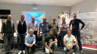 News Gruppe von elf Männern in Tagungsraum mit Projektor und Rollup-Banner