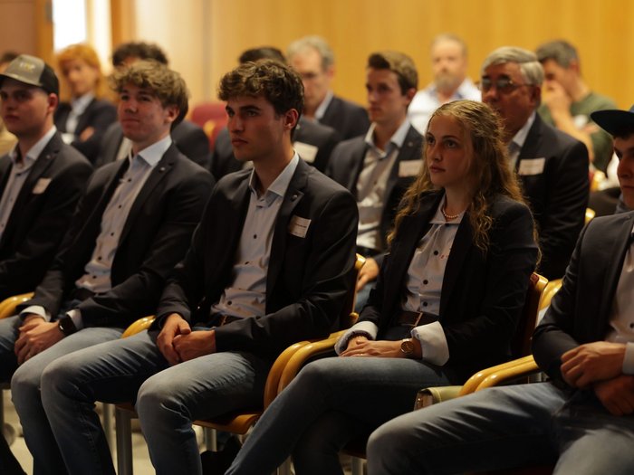 Aperitivo WorldSkills alla Casa dell'Artigianato Giovani adulti in jeans e blazer seduti attentamente durante un evento