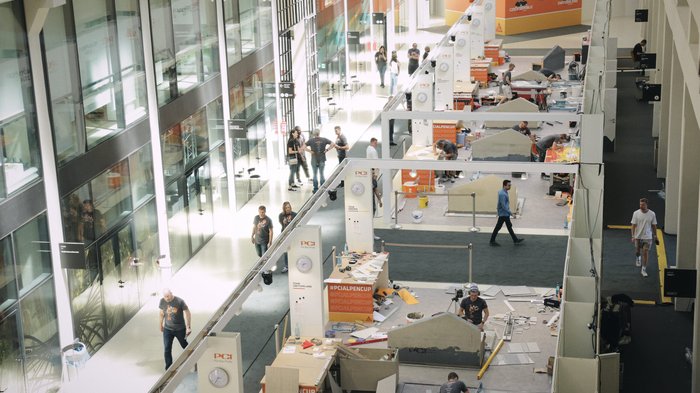 Südtirol begeistert beim Wettkampf der Fliesenleger/innen in Bozen! Menschen arbeiten und gehen in einem modernen Veranstaltungsgebäude mit Wettbewerbsständen
