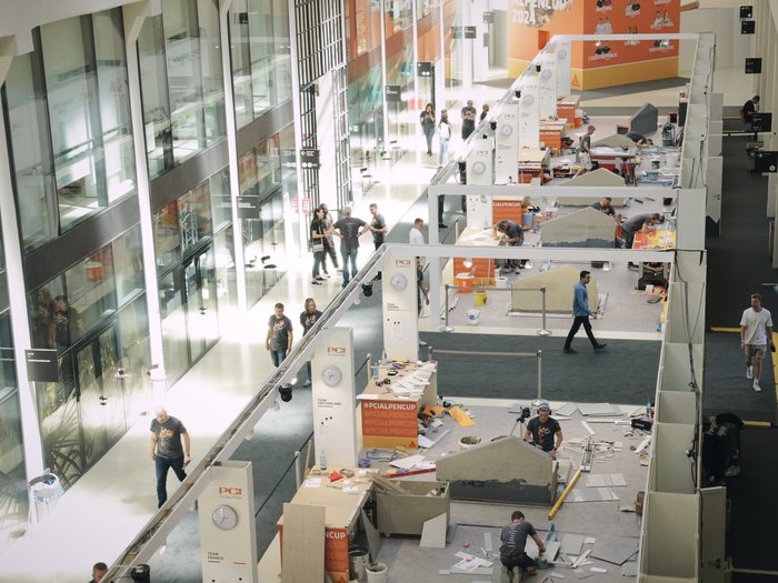 Südtirol begeistert beim Wettkampf der Fliesenleger/innen in Bozen! Menschen arbeiten und gehen in einem modernen Veranstaltungsgebäude mit Wettbewerbsständen