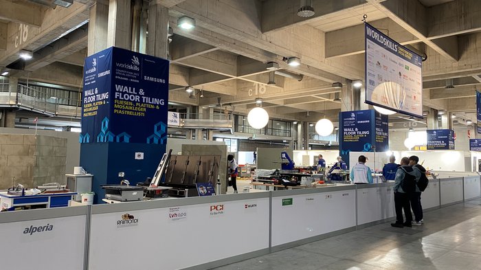 A Bolzano tutto pronto per i campionati mondiali dei mestieri WorldSkills Area di gara piastrellatura con partecipanti e attrezzi alla WorldSkills Competition 2022