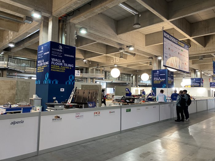 Anpfiff für WorldSkills in Bozen Wettbewerbsbereich Fliesenlegen mit Teilnehmern und Werkzeugen auf der WorldSkills Competition 2022