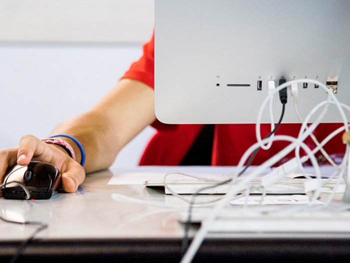 Zugang zu größeren Aufträgen durch Zusammenschlüsse Hand am Computermaus neben einem Monitor auf einem Schreibtisch