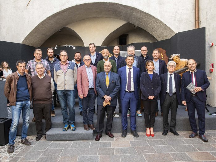 Colori nell’artigianato artistico Foto di gruppo di 18 persone davanti a un arco di edificio storico