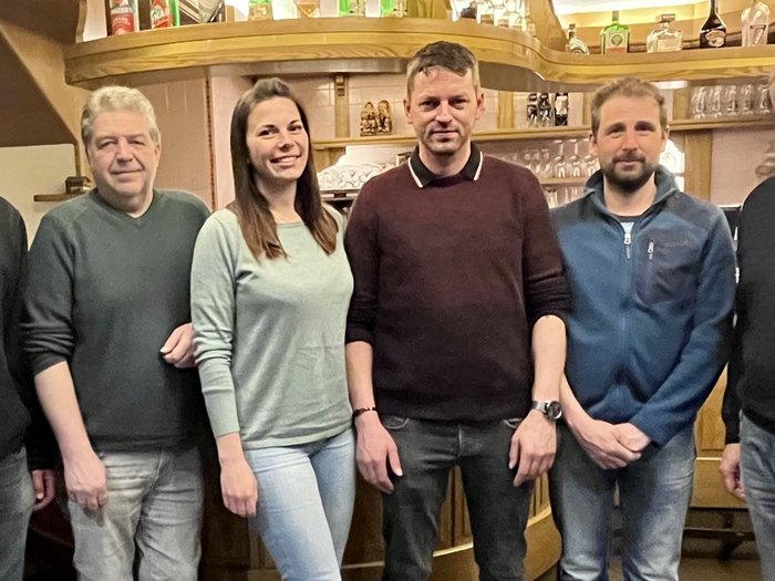 lvh-Ortsversammlung Welschnofen: Handwerk und Gemeindepolitik Sechs Personen stehen in einer Bar vor einem Holzregal mit Gläsern und Flaschen