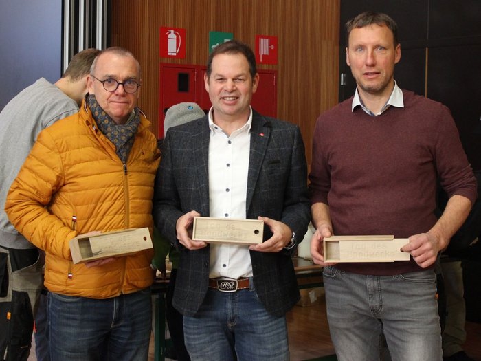 A San Genesio un’intera giornata dedicata all’artigianato Tre uomini tengono scatole di legno incise con Giorno dell'artigianato