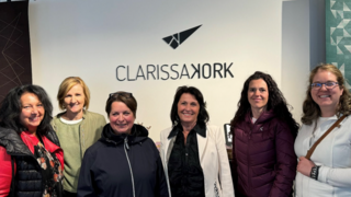 News Sechs lächelnde Frauen stehen vor einer Wand mit dem Clarissa Kork Logo