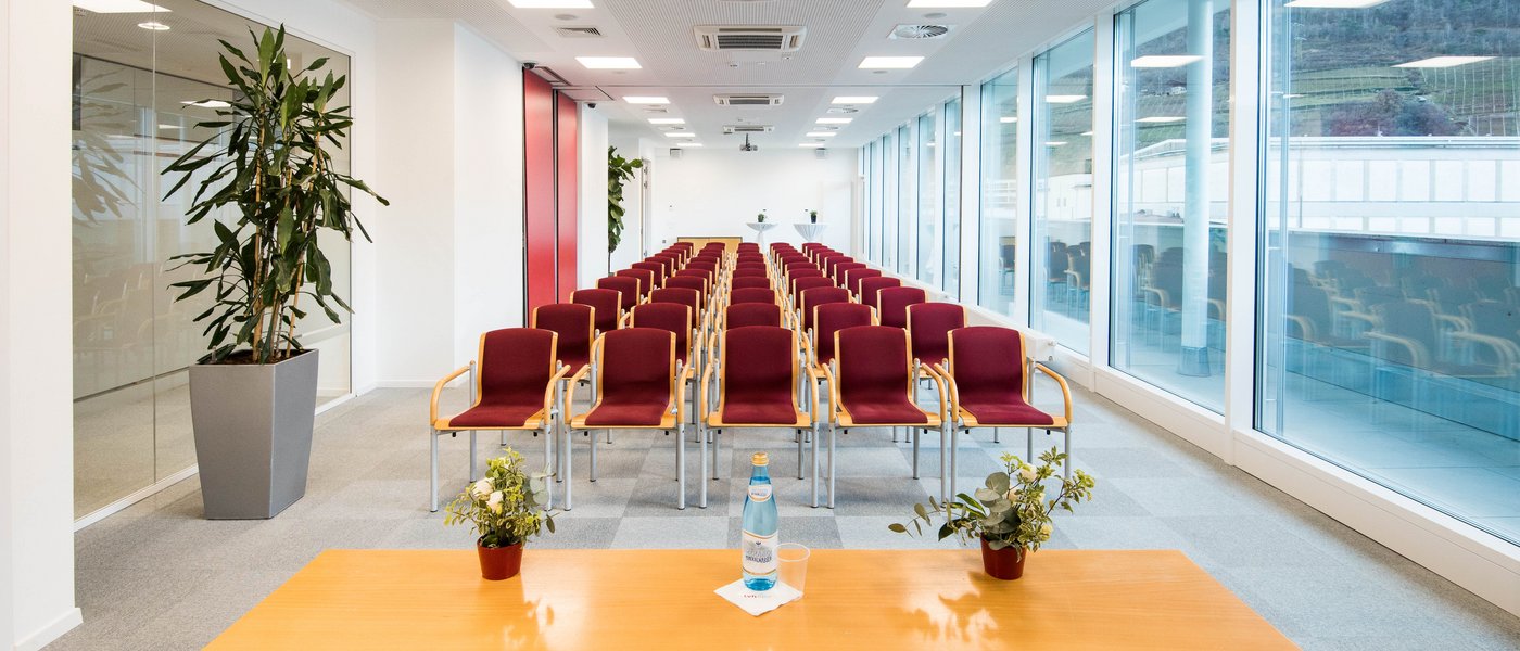 Affitto aule seminari Sala conferenze vuota con file di sedie, tavolo e grandi finestre