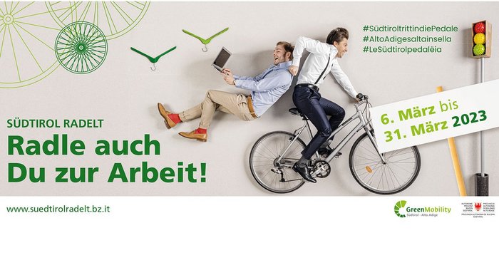 Südtirol radelt. Radle auch Du zur Arbeit! Zwei Männer, einer fährt Fahrrad, der andere sitzt lachend auf dem Gepäckträger
