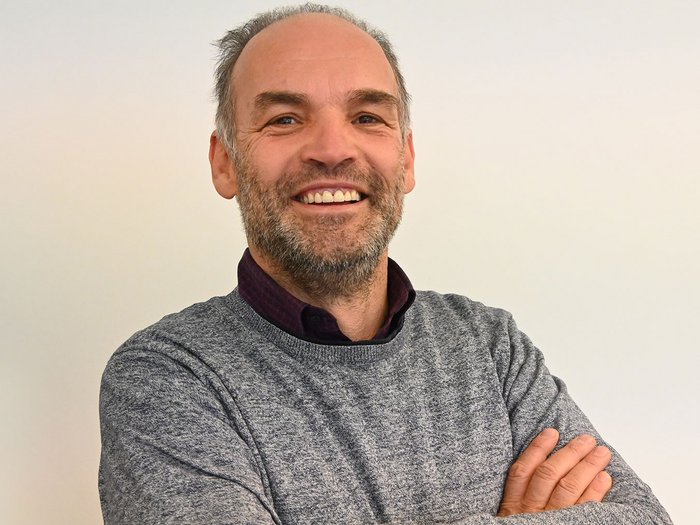 Brenner-Stau: „Es braucht sofort praktikable Lösungen!“ Lächelnder Mann mit grauem Pullover vor weißem Hintergrund