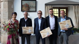 © SAG/Doris Mur Fünf Personen, drei mit Geschenkboxen zum 25-jährigen Jubiläum, eine Frau mit Blumenstrauß