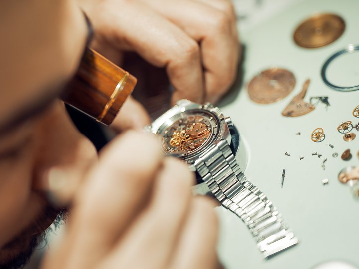 Uhrmacher Uhrmacher repariert eine mechanische Armbanduhr mit Lupe