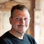 Brixen Porträt eines lächelnden Mannes mit kurzem Haar und schwarzem Pullover