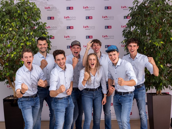 Successo altoatesino alle WorldSkills 2024 di Lione Giovani con camicie e jeans fanno festa davanti a una parete con loghi lvhapa