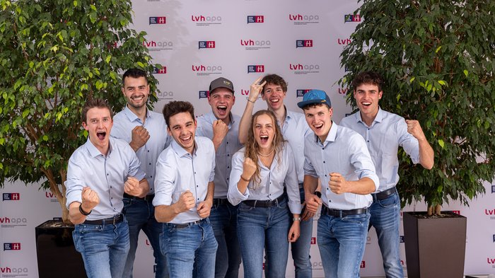 Successo altoatesino alle WorldSkills 2024 di Lione Giovani con camicie e jeans fanno festa davanti a una parete con loghi lvhapa
