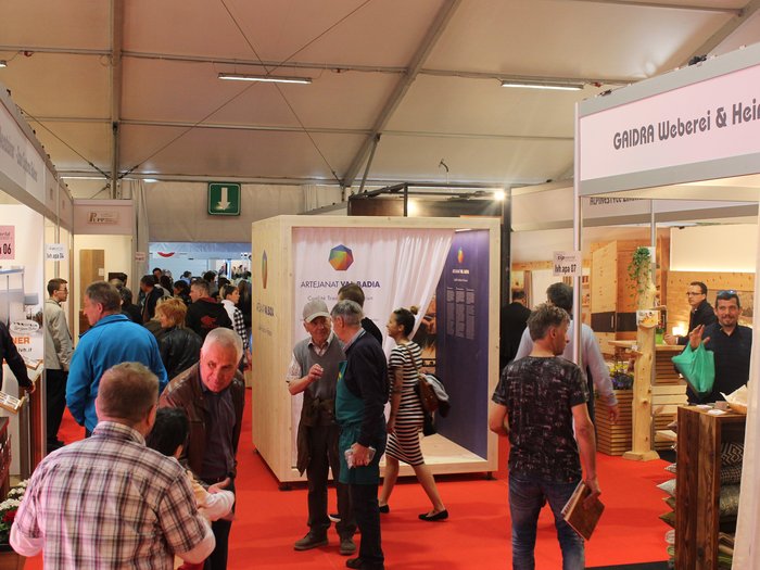 Südtiroler Qualitätshandwerk auf der Tipworld Menschen und Stände auf einer Messe mit roten Teppichboden