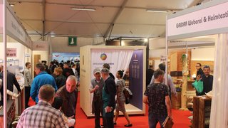 News Menschen und Stände auf einer Messe mit roten Teppichboden