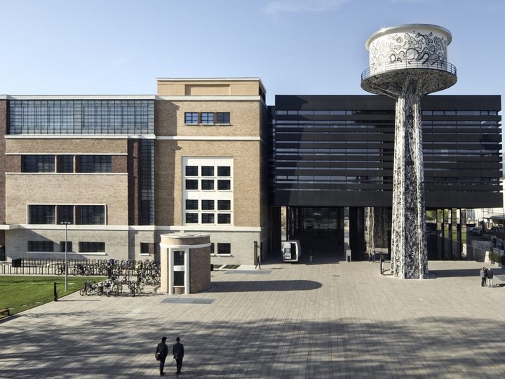 Collaborazioni & network Edificio moderno con facciata in vetro e torre d'acqua dipinta nel cortile