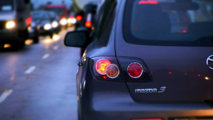 Traffico sulla MeBo: una situazione insostenibile per l’economia Vista posteriore di una Mazda 3 nel traffico serale con luci posteriori accese