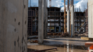 Webinare Bau einer mehrstöckigen Betonstruktur mit Kränen und Baustellenmaterial