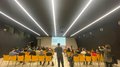 Il futuro è qui: il techParcour Persone sedute su sedie gialle assistono a una presentazione in sala conferenze moderna