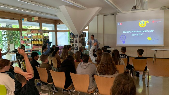 Mittelschule Naturns: Traumberufe in Gastgewerbe und Handwerk vorgestellt Schüler heben Hände in Vortrag über Handwerksberufe im Klassenzimmer