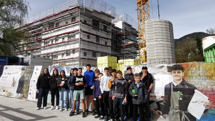 Wahlfach Handwerk Gruppe Jugendlicher vor einer Baustelle mit Gerüst und Kran