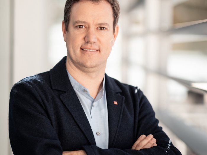 Grüner Pass: Nachteil für Südtirols Kleinbetriebe Porträt eines lächelnden Mannes mit verschränkten Armen im modernen Büro