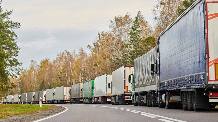 Divieto di transito notturno in Tirolo: una scelta ingiustificata Camion fermi in una lunga fila su una strada di campagna in autunno