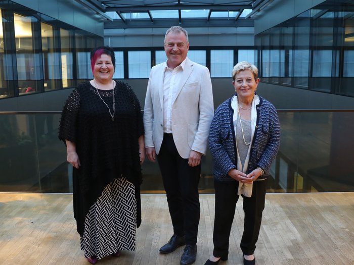 Neuer Obermeister des Südtiroler Meisterbundes Drei lächelnde Personen in einem modernen Gebäude mit Glasdach
