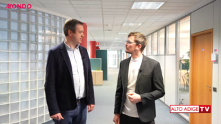 News Zwei Männer im Gespräch in einem modernen Büroflur