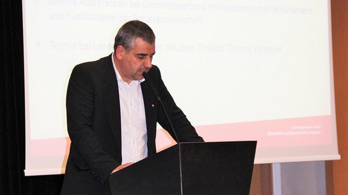 Mietwagenunternehmer: Auf Weissensteiner folgt Thaler Mann hält eine Rede am Rednerpult mit Projektionsleinwand im Hintergrund